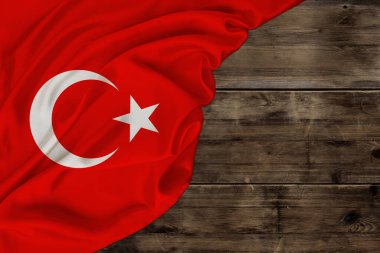 Türkiye devletinin ipek ulusal bayrağı yazı, turizm, ekonomi ve siyaset kavramı için eski ahşap üzerine yumuşak kıvrımlarla uzanmaktadır.