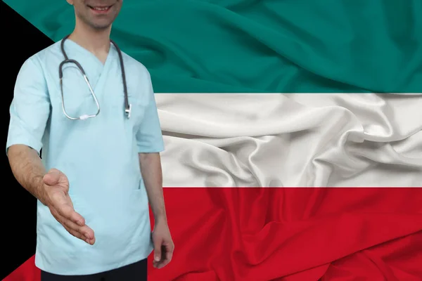 partial photograph of the doctor in uniform against the background of the Kuwait national flag on delicate shiny silk, the concept of medical care and insurance in the country, close-up, copy space