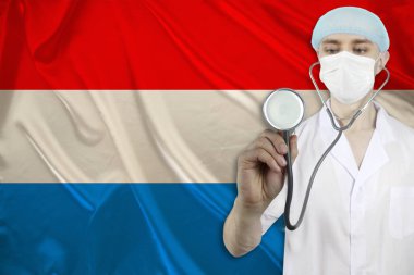 Lüksemburg 'un ipek ulusal bayrağının arka planında steteskoplu erkek doktor, ulusal sağlık, sağlık, sigorta, turizm kavramı