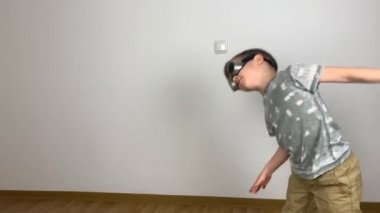 Gözlüklü küçük çocuk özverili bir şekilde dans eder komik bir dans eder ve etrafta maskaralık yapar, yaratıcı bir konsept.