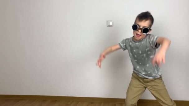 戴眼镜的小男孩无私地跳着滑稽的舞步 到处都是傻瓜 充满创意 — 图库视频影像