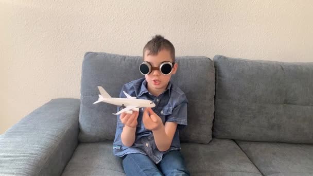 Kind Mit Schwarzer Brille Spielt Mit Weißem Flugzeugspielzeug Konzept Flucht — Stockvideo