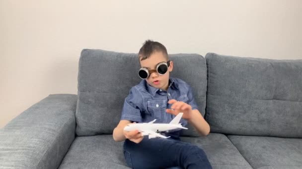 Kind Mit Schwarzer Brille Spielt Mit Weißem Flugzeugspielzeug Konzept Flucht — Stockvideo