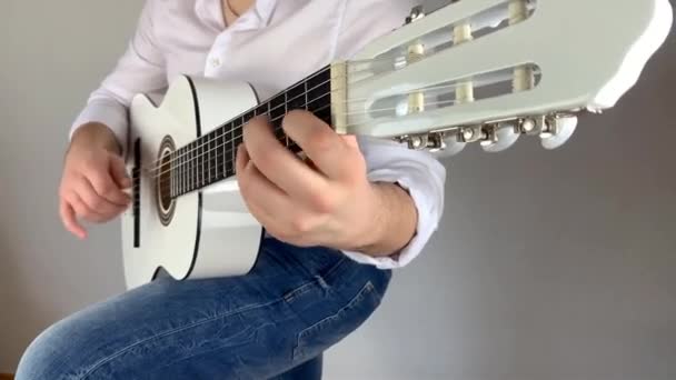 Man Wit Shirt Speelt Zes Snarige Klassieke Gitaar Thuis Concept — Stockvideo