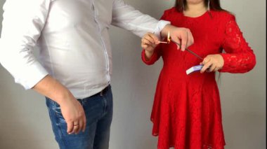 Beyaz gömlekli genç bir adam ve şık kırmızı elbiseli bir kız ellerinde maytap, bir tatil konsepti, romantik bir randevu tutuyorlar.