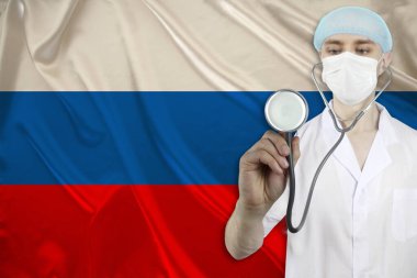 Rusya 'nın ipek ulusal bayrağının arka planında steteskoplu erkek doktor, ulusal sağlık, sağlık, sigorta, turizm kavramı