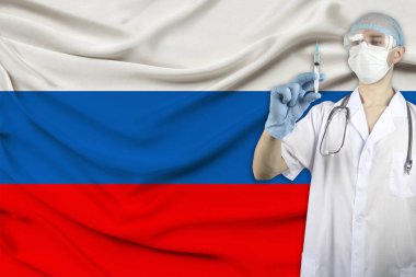Rusya 'nın ulusal bayrağının arka planına karşı bir doktorun ellerine iğne şırıngası, aşı, salgın, aşı konsepti