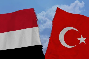 Yırtık kumaş üzerinde iki renkli bayrak, uluslararası ilişkilerin sembolü Türkiye ve Yemen, küresel iş kavramı, siyasi ve ekonomik ilişkilerin bozulması