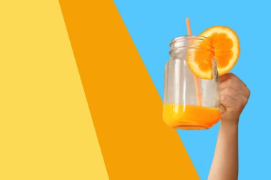 Neşeli çocuk uzanmış elinde cam bir kavanoz tutuyor. Portakal suyu ya da limonlu pipetle. Sağlıklı beslenme, vitamin, yaşam tarzı.