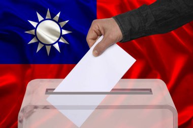 Erkek seçmen saydam bir oy sandığında Tayvan bayrağının arka planına, devlet seçimlerine ve referanduma karşı oy kullanıyor.