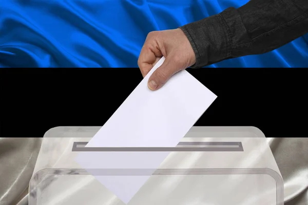 Męski Wyborca Upuszcza Kartę Głosowania Przejrzystej Urnie Tle Estońskiej Flagi — Zdjęcie stockowe