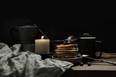 Ulusal gözleme, krep, yaban mersinli pide, keten peçete, mum yanıkları, bir fincan çay, eski bir kahve makinesi, geleneksel mutfak konsepti.