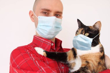 Beyaz tıbbi antiviral maskeli genç erkek ve evcil kedi, SARS-CoV-2, COVID-19 virüs salgını, koronavirüs, karantina