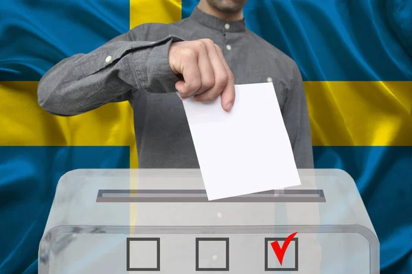 Mężczyzna Wyborca Upuszcza Kartę Głosowania Przejrzystej Urnie Głosowania Tle Flagi — Zdjęcie stockowe