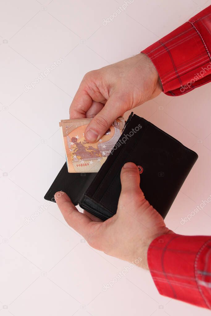 young man takes out folded in half euro banknotes from a purse, business concept, purchase, cash