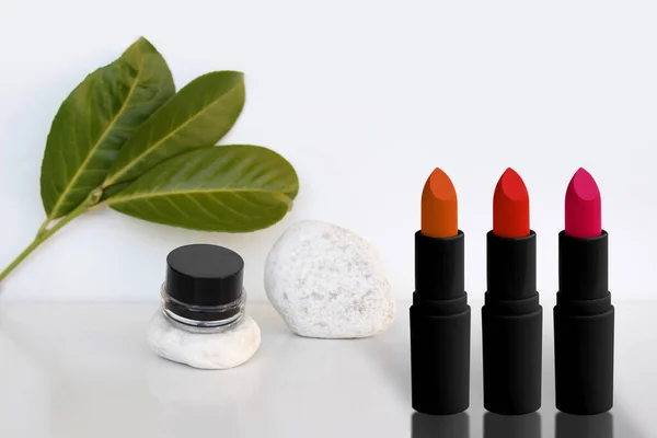 Serie Tubi Rossetto Sta Uno Sfondo Bianco Con Foglie Verdi — Foto Stock