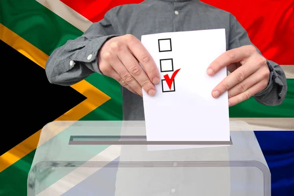 Mężczyzna Wyborca Upuszcza Karty Głosowania Przejrzystej Urnie Głosowania Tle Flagi — Zdjęcie stockowe