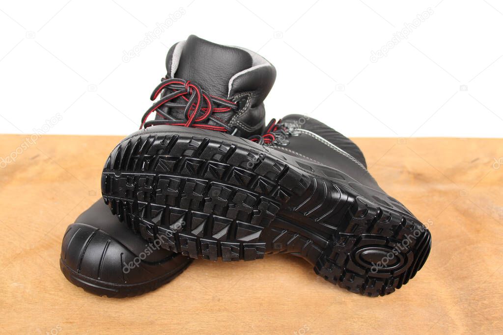 pair of new black work boots made of genuine leather with a reinforced cape, the concept of special shoes for different professions, traces, protectors