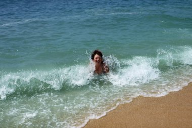 Bir kadın fırtınada dalgalarda yüzer, tatil konsepti, yolculuk