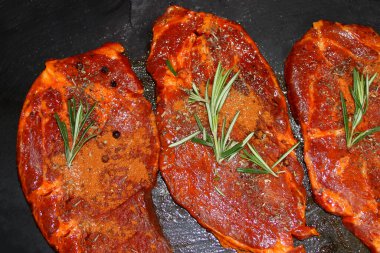 Siyah tahtada baharatlarla marine edilmiş çiğ et, biberiyeli biftek protein beslenme, diyet, barbekü partisi, ev yapımı yemek konsepti.