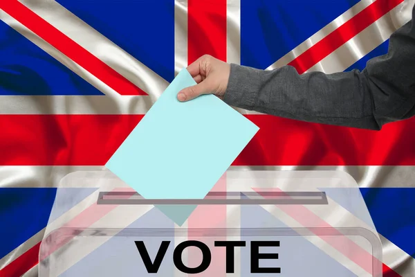 男性の有権者は 英国の国旗 州の選挙の概念 国民投票を背景に 透明な投票箱に投票を落とします — ストック写真