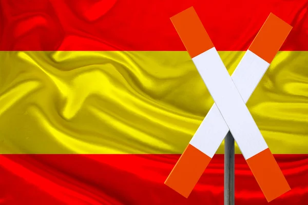 customs sign, stop, attention against the background of the silk national flag of Spain, the concept of border and customs control, violation of the state border, tourism restrictions