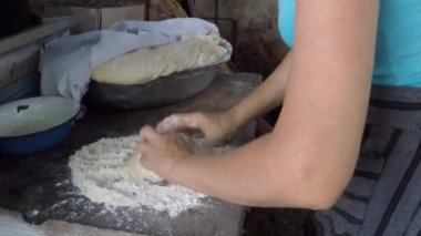 Kadın Gürcistan 'da bir kil dikenli fırında ekmek pişiriyor, Gürcistan' da ulusal hamur işleri hazırlıyor, geleneksel Gürcü mutfağı kavramı, ev işi, kadın işi