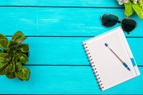 ペン、花、青い木製の背景に眼鏡のノート — ストック写真