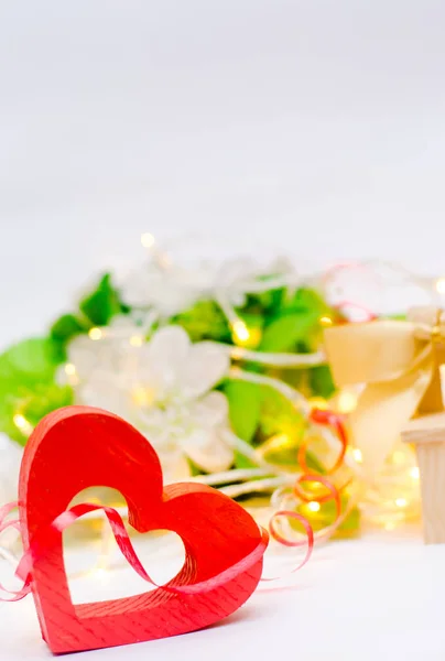Houten hart met een boog op een bankje op een witte achtergrond. Aftelkalender voor Valentijnsdag. concept liefde — Stockfoto