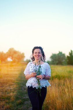 mutlu genç güzel esmer kız ile buket çiçegi alanında eller. açık havada. yaz günbatımı