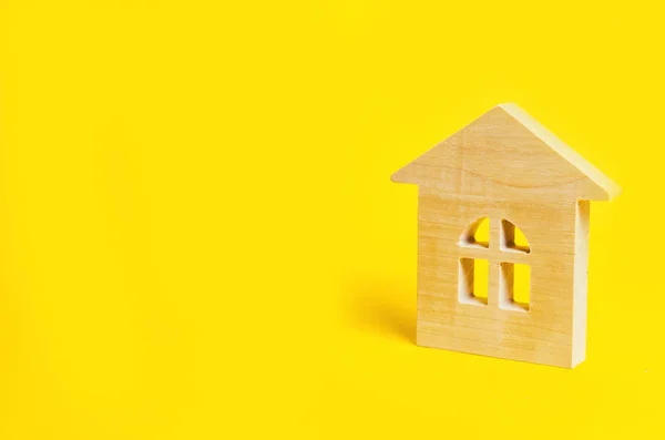 Модель дерев'яного будинку на жовтому тлі, ізольовано, концепція нерухомості, місце для тексту — стокове фото