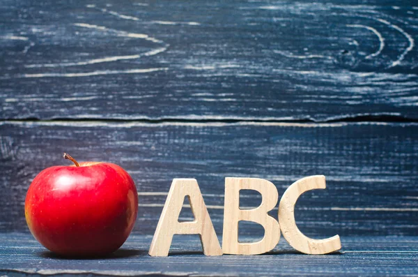 Maçã vermelha e cartas ABC em um fundo escuro de um conselho de escola — Fotografia de Stock