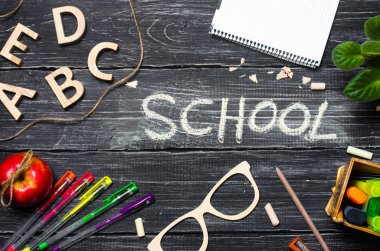 Bir öğrencinin masanın üzerine okul yönetimi kurulları koyu ahşap arka plan yaptı. Eğitim ve okul kavramı. Yazıt okul. Ofis tablodur. Üstten Görünüm, metin için yer. Çalışma alanı.