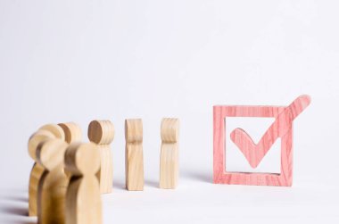 ahşap insan figürleri birlikte bir onay kutusunun yanındaki bekletin. Seçimler ve sosyal teknolojileri kavramı. Gönüllüler, partiler, adaylar, seçim electorates. Seçici odak