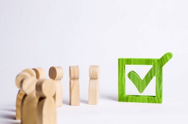 ahşap insan figürleri birlikte bir onay kutusunun yanındaki bekletin. Seçimler ve sosyal teknolojileri kavramı. Gönüllüler, partiler, adaylar, seçim electorates. Seçici odak