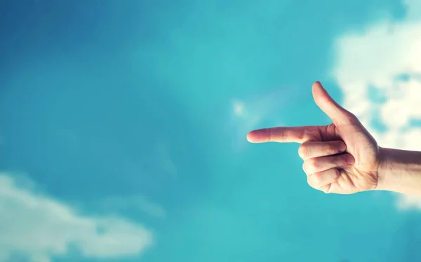 finger pointing at something and blue sky, place for text