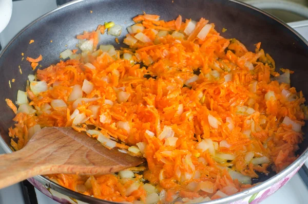 Cooked soup ingredient. Sauteed chopped onions and grated carrots for soup in a frying pan. fried vegetables — Stock Photo, Image