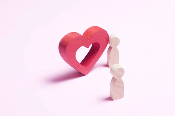 Un hombre se para cerca del corazón y confiesa amor en un backgro rosa —  Fotos de Stock