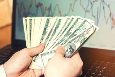 bilgisayar arka plan, internette, yatırım, başarı, satın alma kavramı üzerinde elinde dolar kumar. internet dolandırıcılığı, uzun bacaklı kazanç. kirli para.