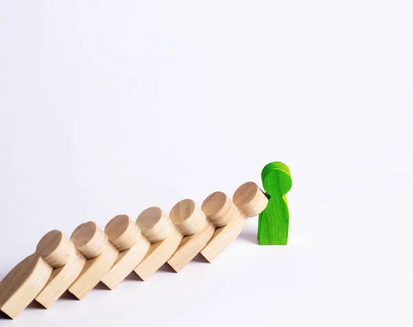 People in line fall like dominoes. Green man stops the fall of people as dominoes. The concept of durability and strength, business ideas. Willpower, strong nerves, strong character. Stubbornness.