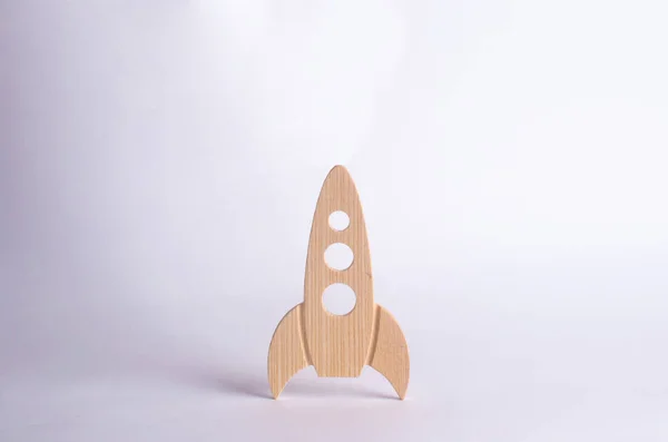 Wooden space rocket on a white background. The concept of space and technology, travel to the stars and other planets. Space tourism. Launch of spaceships. Isolate.