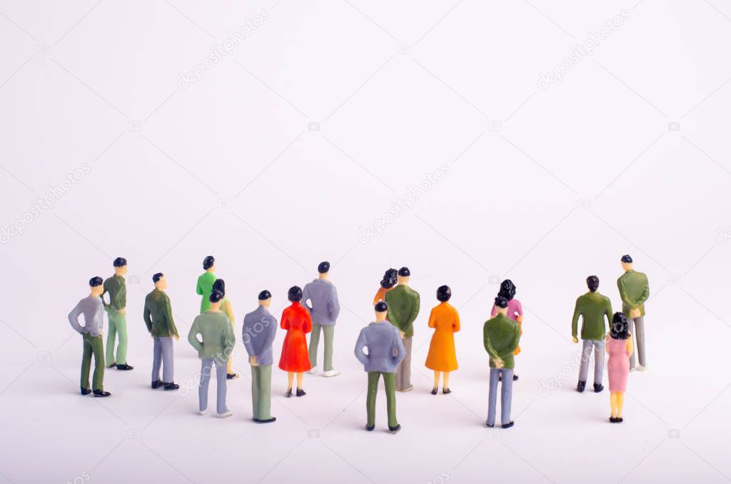 A crowd of people is standing and looking at the white background. People are looking at the white screen. Place for text. The society is watching the event. Observation of the object. Selective focus