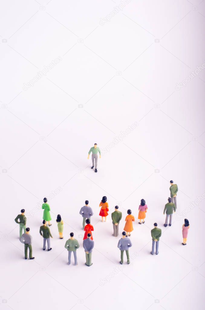 The crowd is looking at the man who comes towards her on a white background. The man is approaching a group of people. Leader of the team, messiah, leader. A new person at work. Selective focus.