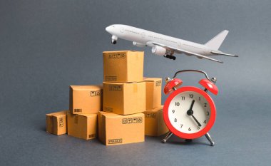 Kargo uçağı, karton kutular ve kırmızı alarm saati. Hava teslimatı konsepti. Geçici depo, sınırlı teklif ve indirim. Lojistiğin iyileştirilmesi, verimliliğin artırılması