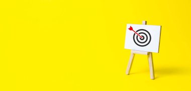 Sign stand with an arrow in the target on a yellow background. Hit exactly on center. Tactics of advertising targeting. advertise campaigns. Goal Achievement and Purposefulness