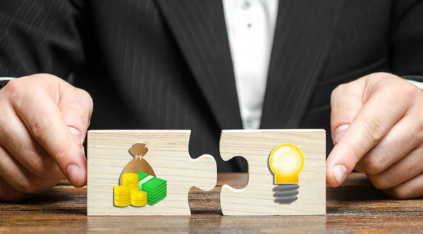 İş adamı, para imajı ve bir fikir ampulü ile iki bulmaca çözer. Gelecek vaat eden girişimleri finanse etmek ve bir iş kurmak için yatırım yapmak. Araştırma ve teknoloji. Bağışlar