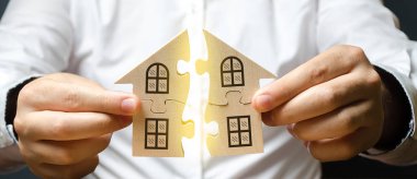 Bir adam yazıt Mortgage üzerinde bütün bir eve iki bulmaca bağlanır. Kendi konut binanızın inşaatı. Kredi kredisi ile ev satın almak, yaşam koşullarının iyileştirilmesi