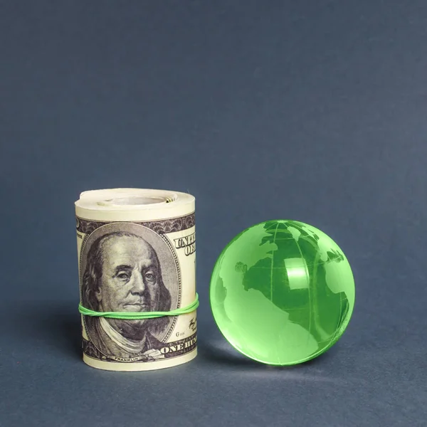Roll of dollars and green planet earth globe. International money transfers, attraction of investments. Global financial system. World trade and economic relations ties. Business industry. minimalism