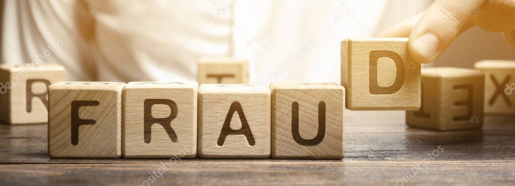 Wooden blocks with the word Fraud and man. Cheating white-collar . The crime. Theft of another's property. Anti-corruption in the financial sector. Deception and abuse of trust.