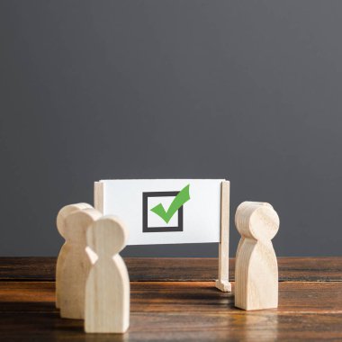 İnsanlar yeşil işaretli bir beyaz tahtayı çevreledi. Doğru kolektif seçim, akıllıca strateji ve öngörü. Seçimde oy kullanma. Doğruluk ve doğruluğun onaylanması, kalite değerlendirmesi.